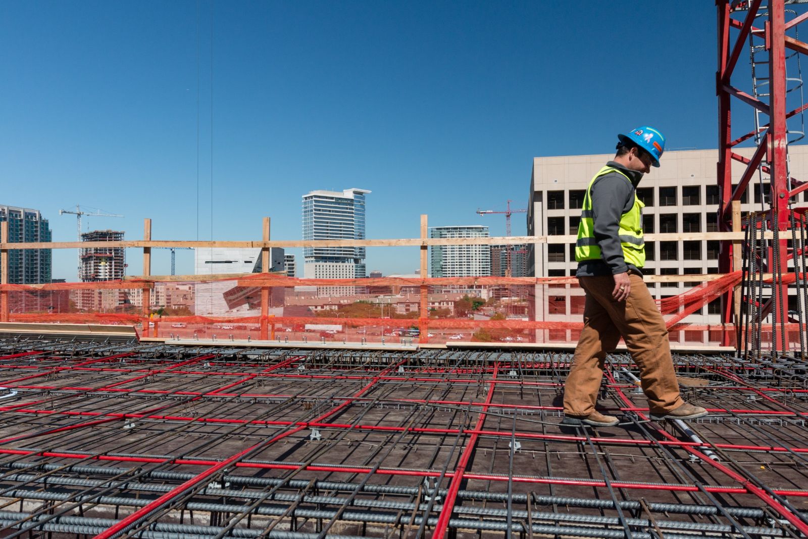Superintendent walking across a rebar deck above the city skyline